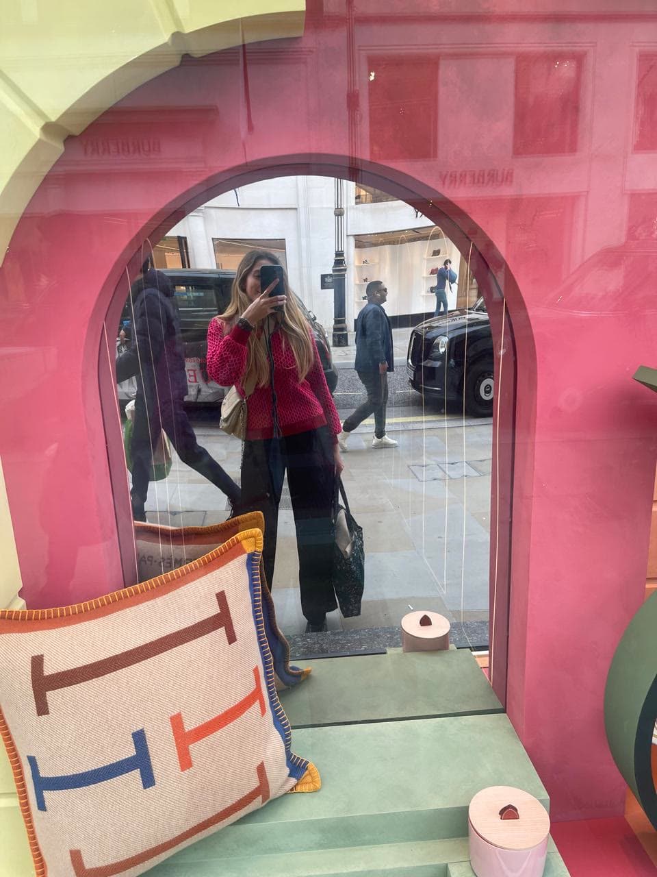 Reflexo na vitrine da Hermès, com a fachada da Burberry do outro lado de Bond Street